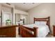 Cozy bedroom with ceiling fan, tile floors, wooden bed frame, and large mirrored closet at 205 N 74Th St # 166, Mesa, AZ 85207