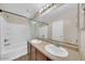 Bright bathroom with double sink vanity, large mirror, and a shower-tub combination with white tile surround at 2118 N 77Th Ln, Phoenix, AZ 85035