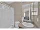A functional bathroom features a shower with curtain, a vanity with sink, and essential fixtures at 2118 N 77Th Ln, Phoenix, AZ 85035