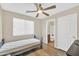 Bedroom featuring a ceiling fan, large window, and private access to an en-suite bathroom at 2118 N 77Th Ln, Phoenix, AZ 85035