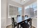 Bright breakfast nook features a dark wood table and matching chairs next to sunlit windows with modern blinds at 2118 N 77Th Ln, Phoenix, AZ 85035