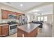 Modern eat-in kitchen with stainless appliances, light countertops, and access to the living room at 2118 N 77Th Ln, Phoenix, AZ 85035