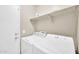 A practical laundry area includes a washer, dryer, and shelf space for supplies at 2118 N 77Th Ln, Phoenix, AZ 85035