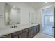 Bathroom with dual sinks, white quartz countertops, and a view into the bedroom at 2121 W Sonoran Desert Dr # 32, Phoenix, AZ 85085