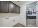 Functional laundry room with wood-look tile flooring and overhead cabinet storage at 2121 W Sonoran Desert Dr # 32, Phoenix, AZ 85085