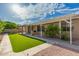 Spacious backyard with mature trees, turf, covered patio, and desert landscaping at 2183 W Hawken Way, Chandler, AZ 85286