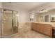 Bathroom featuring a glass-enclosed shower, a soaking tub, and vanity cabinets that combine style and functionality at 2183 W Hawken Way, Chandler, AZ 85286