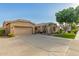 Tan home with a two-car garage, well kept front yard, desert landscaping, and extended concrete driveway at 2183 W Hawken Way, Chandler, AZ 85286