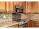 Close-up of a gourmet kitchen featuring custom cabinetry and stainless oven and microwave at 2183 W Hawken Way, Chandler, AZ 85286