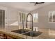 Close-up of a kitchen sink with granite counters and view through shuttered window at 2183 W Hawken Way, Chandler, AZ 85286