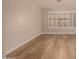 Home interior showcasing an empty room with light wood floors, white trim, and plantation shutters at 2183 W Hawken Way, Chandler, AZ 85286