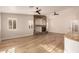 Bright living room featuring wood floors, stone fireplace, and two ceiling fans at 2183 W Hawken Way, Chandler, AZ 85286