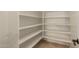 A well organized pantry features white shelving for ample storage, keeping kitchen essentials neatly stored and readily accessible at 2183 W Hawken Way, Chandler, AZ 85286