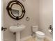 Classic powder room featuring a decorative mirror, pedestal sink, and tiled flooring, creating an elegant and functional space at 2183 W Hawken Way, Chandler, AZ 85286