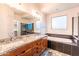Modern bathroom featuring double vanity, granite countertops, tub, and glass-enclosed shower at 22721 N 34Th St, Phoenix, AZ 85050