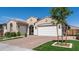 Exterior featuring a three-car garage, lush front lawn, brick-paved driveway and well-maintained landscaping at 22721 N 34Th St, Phoenix, AZ 85050