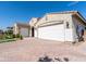 A front shot of a house featuring a 3-car garage, brick-paved driveway and a beautifully landscaped front yard at 22721 N 34Th St, Phoenix, AZ 85050