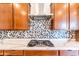 Close-up of a kitchen backsplash featuring mosaic tile and stainless steel range hood at 22721 N 34Th St, Phoenix, AZ 85050