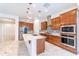Modern kitchen featuring custom wood cabinetry, stainless steel appliances, and a marble island at 22721 N 34Th St, Phoenix, AZ 85050