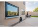 View of the stucco house exterior with a large picture window and backyard with patio furniture at 24433 N 75Th St, Scottsdale, AZ 85255
