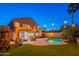 A serene backyard featuring string lights, a sparkling pool, and cozy seating, creating a warm and inviting outdoor space at night at 24433 N 75Th St, Scottsdale, AZ 85255