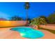 A tranquil backyard at night featuring a sparkling pool surrounded by lush landscaping and a serene ambiance at 24433 N 75Th St, Scottsdale, AZ 85255