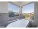 Bright bathroom features a luxurious soaking tub with neighborhood views from large picturesque windows at 24433 N 75Th St, Scottsdale, AZ 85255