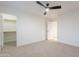 Spacious bedroom featuring neutral carpet, ceiling fan, and an open doorway to a closet and ensuite bathroom at 24433 N 75Th St, Scottsdale, AZ 85255