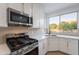 Modern kitchen with stainless steel appliances, white cabinets, and a view of the backyard oasis from the window at 24433 N 75Th St, Scottsdale, AZ 85255