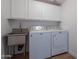 Convenient laundry room with white cabinetry, stainless sink, and modern Maytag washer and dryer at 24433 N 75Th St, Scottsdale, AZ 85255