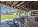 Covered patio with a dining table that overlooks the pool and spa; with artificial grass and trees at 2724 W Colt Rd, Chandler, AZ 85224