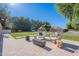 Seating arrangement with two egg chairs and outdoor fireplace, located next to a grassy backyard and lush trees at 2724 W Colt Rd, Chandler, AZ 85224