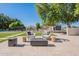 Backyard retreat featuring two stylish egg chairs, a modern fire pit, artificial turf, and lush landscaping at 2724 W Colt Rd, Chandler, AZ 85224