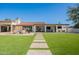 Large backyard featuring artificial turf, stone pathway, covered patios, egg chairs, and a desert landscape at 2724 W Colt Rd, Chandler, AZ 85224