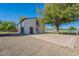 View of white barn with dual garage doors and spiral stairs on the side surrounded by gravel and trees at 2724 W Colt Rd, Chandler, AZ 85224
