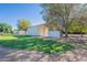 Exterior shot of white barn in a grassy lot with a few mature trees at 2724 W Colt Rd, Chandler, AZ 85224