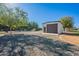 Detached garage with gravel landscaping, mature trees, with a glimpse of the pool and pergola at 2724 W Colt Rd, Chandler, AZ 85224