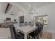 Elegant dining area featuring a long table, modern chandelier, and views into the living room at 2724 W Colt Rd, Chandler, AZ 85224