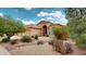 Attractive front yard featuring desert landscaping with a home showcasing arched windows and a tile roof at 2845 E Calavar Rd, Phoenix, AZ 85032