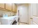 This laundry room has a front loading washer/dryer and overhead storage cabinets at 2845 E Calavar Rd, Phoenix, AZ 85032