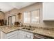 Granite counters accent stainless dishwasher and sink beneath a sunny window in this kitchen at 2941 N Oregon St # 12, Chandler, AZ 85225