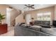 Neutral living room with tile flooring, a grey sofa, staircase, and a ceiling fan at 2941 N Oregon St # 12, Chandler, AZ 85225