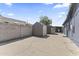 Backyard with a block fence and storage sheds on a concrete patio at 3307 W Willow Ave, Phoenix, AZ 85029
