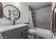 Modern bathroom featuring gray tiles, and a stylish vanity with round mirror at 3307 W Willow Ave, Phoenix, AZ 85029