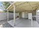 This concrete floor carport has string lights and a white door and refrigerator at 3307 W Willow Ave, Phoenix, AZ 85029