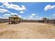 Large backyard with a covered gazebo area with a dining table and chairs and a fenced yard at 3529 N Brooklyn Dr, Buckeye, AZ 85396
