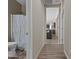 Hallway view of a bathroom with a seahorse shower curtain with an adjacent view of the living room at 3529 N Brooklyn Dr, Buckeye, AZ 85396