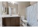 Neutral bathroom with a white sink and vanity, a large mirror, toilet, and shower with a blue seahorse curtain at 3529 N Brooklyn Dr, Buckeye, AZ 85396