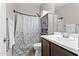 Bathroom featuring a neutral color scheme, a stylish shower curtain, cabinet, and updated fixtures and finishes at 3529 N Brooklyn Dr, Buckeye, AZ 85396