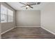 Empty bedroom featuring modern wood floors, a bright window with blinds, and neutral colored walls at 3529 N Brooklyn Dr, Buckeye, AZ 85396